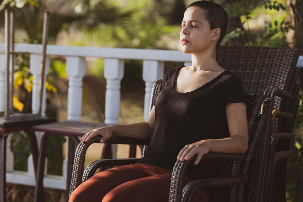 woman in chair outside deep breathing